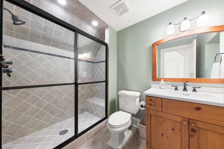 711 South County Line Road Hinsdale, IL 60521 - Photo 30 of 42 a bathroom with a sink a toilet a mirror and shower