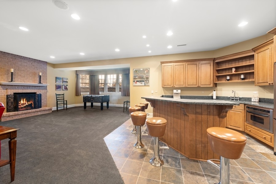 711 South County Line Road Hinsdale, IL 60521 - Photo 33 of 42 a living room with furniture a fireplace a flat screen tv and a window