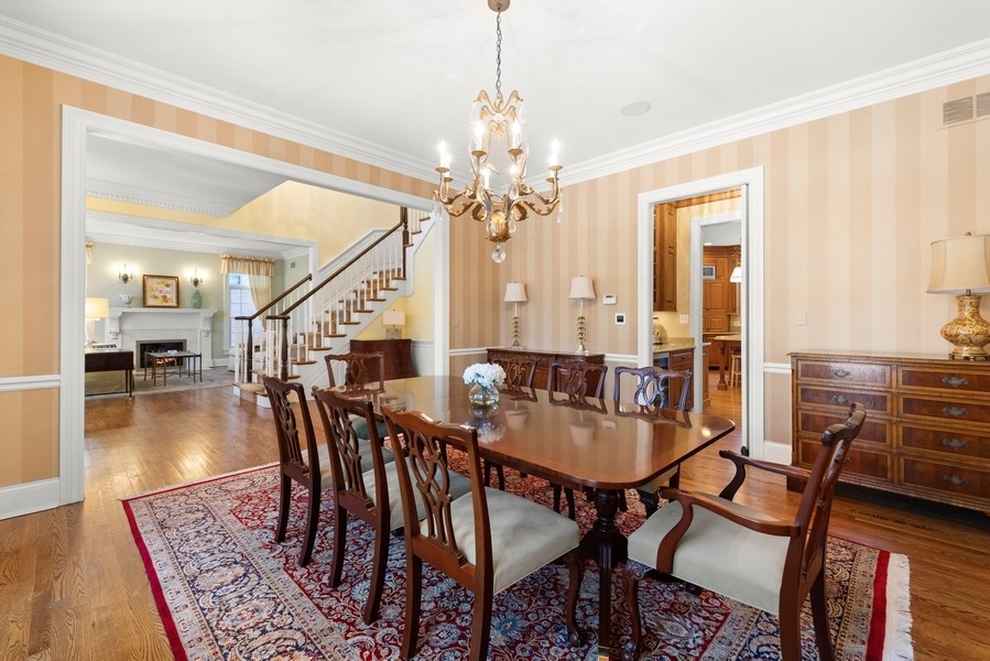 711 South County Line Road Hinsdale, IL 60521 - Photo 6 of 42 a dining room with wooden floor a chandelier a wooden table and chairs