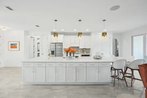 a kitchen with white cabinets and sink