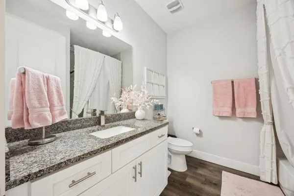 a bathroom with a granite countertop sink and a mirror