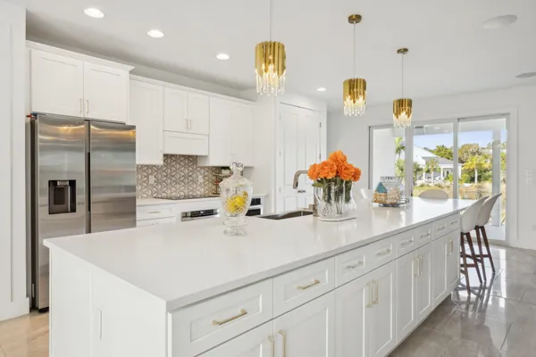 a kitchen with stainless steel appliances a sink a center island and furniture