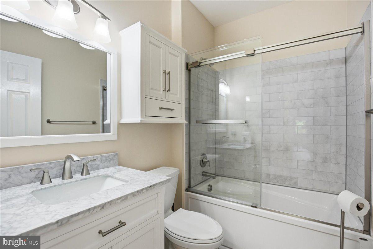 1126 Back Creek Loop, Unit 1126 Solomons, MD 20688 - Photo 36 of 47 a bathroom with a granite countertop sink toilet and shower