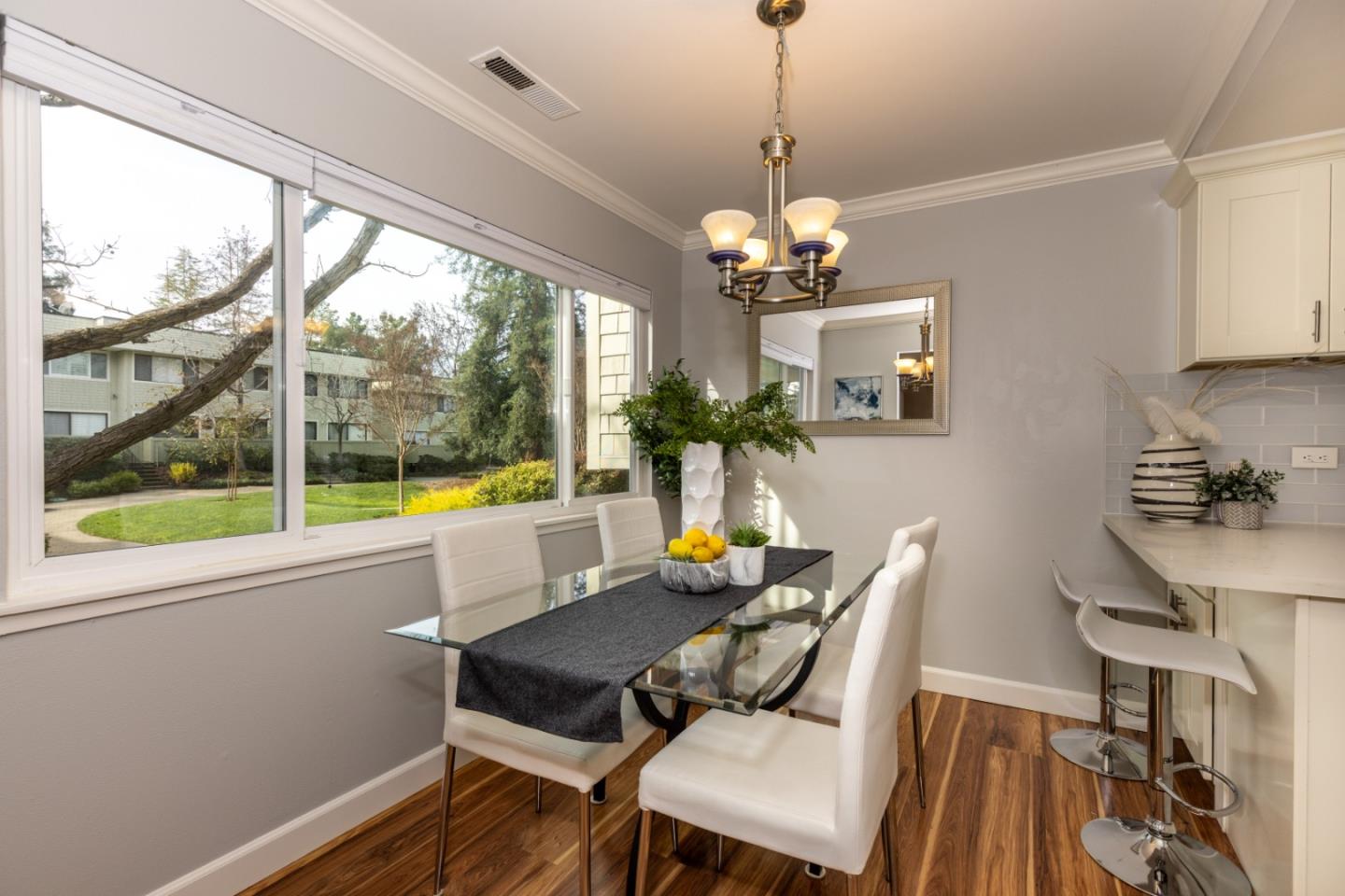 2379 Sharon Road Menlo Park, CA 94025 - Photo 7 of 19 a dining room with wooden floor a chandelier a glass table and chairs