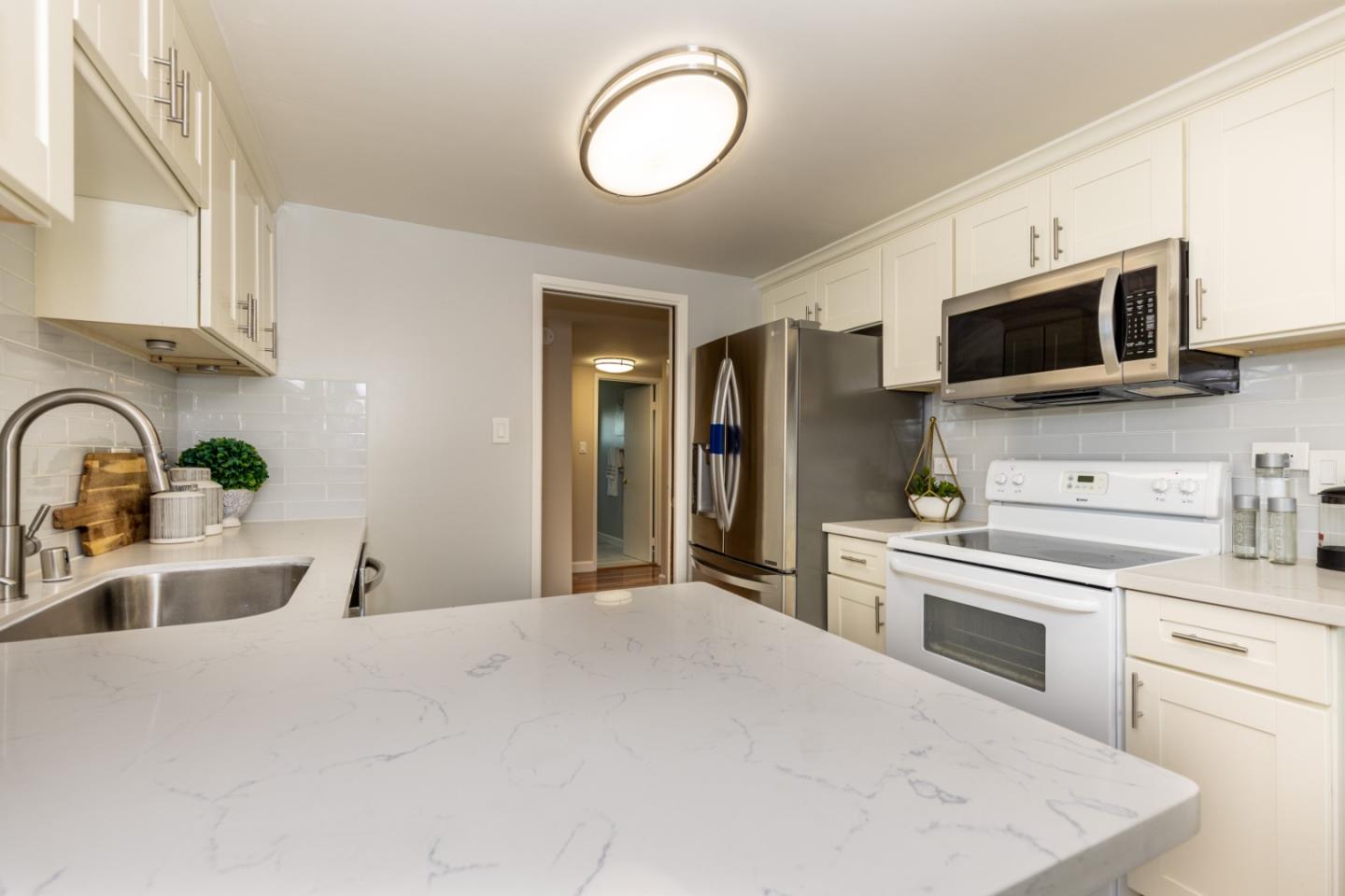 2379 Sharon Road Menlo Park, CA 94025 - Photo 8 of 19 a kitchen with stainless steel appliances a stove microwave and sink