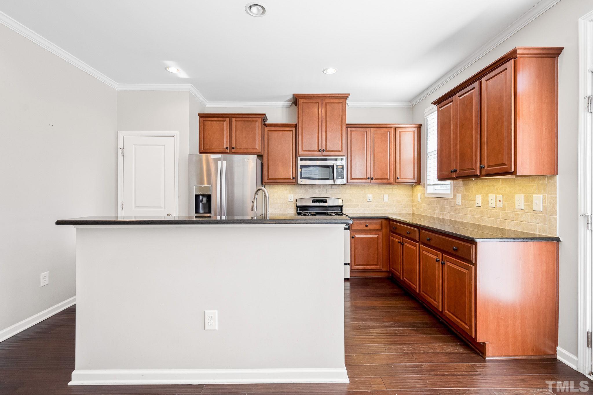 5637 Wade Park Boulevard Raleigh, NC 27607 - Photo 14 of 37 a kitchen with stainless steel appliances granite countertop a refrigerator a stove a sink and a microwave