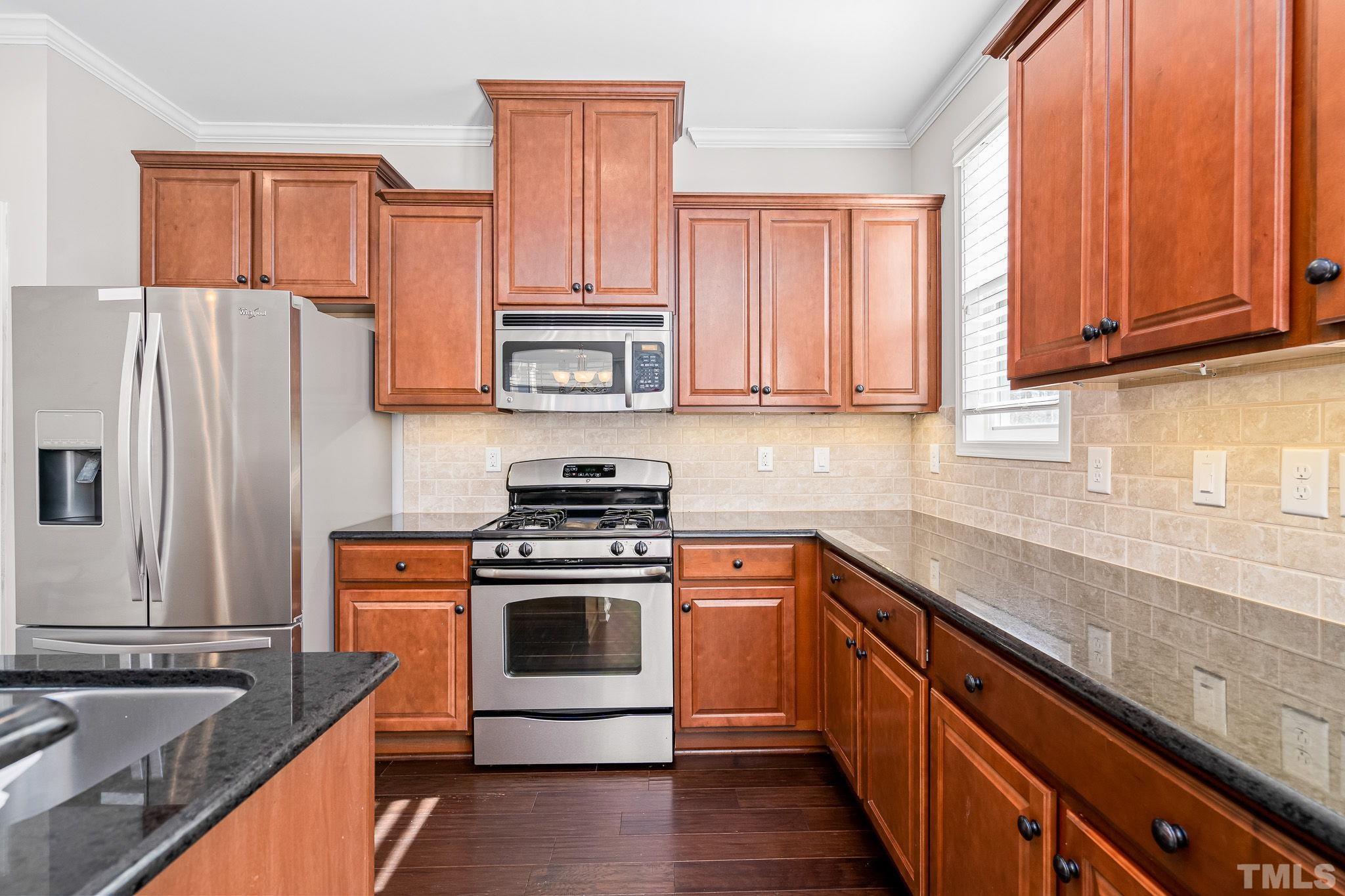 5637 Wade Park Boulevard Raleigh, NC 27607 - Photo 15 of 37 a kitchen with stainless steel appliances granite countertop a stove sink and refrigerator