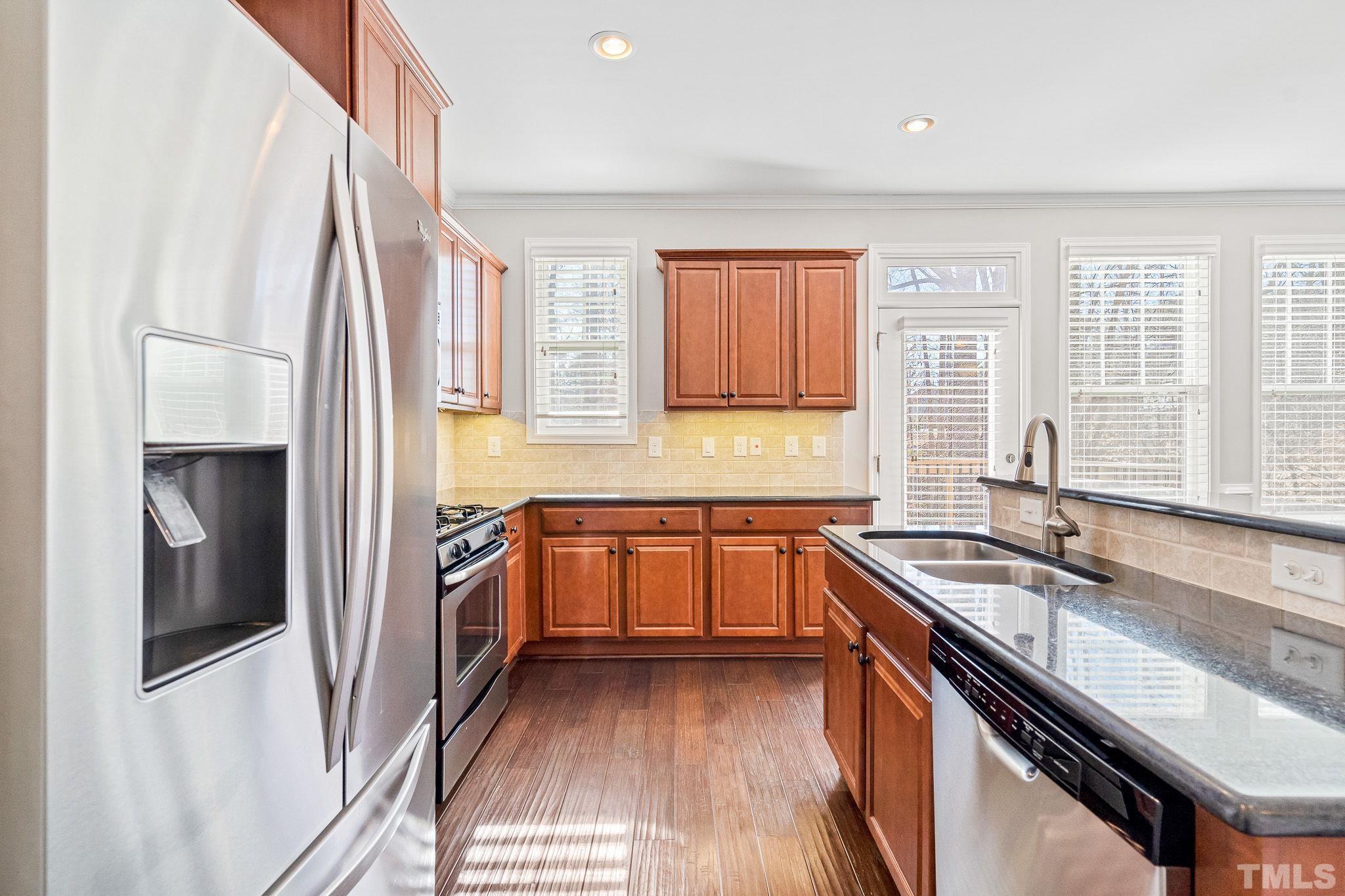 5637 Wade Park Boulevard Raleigh, NC 27607 - Photo 16 of 37 a kitchen with stainless steel appliances granite countertop a sink stove and refrigerator
