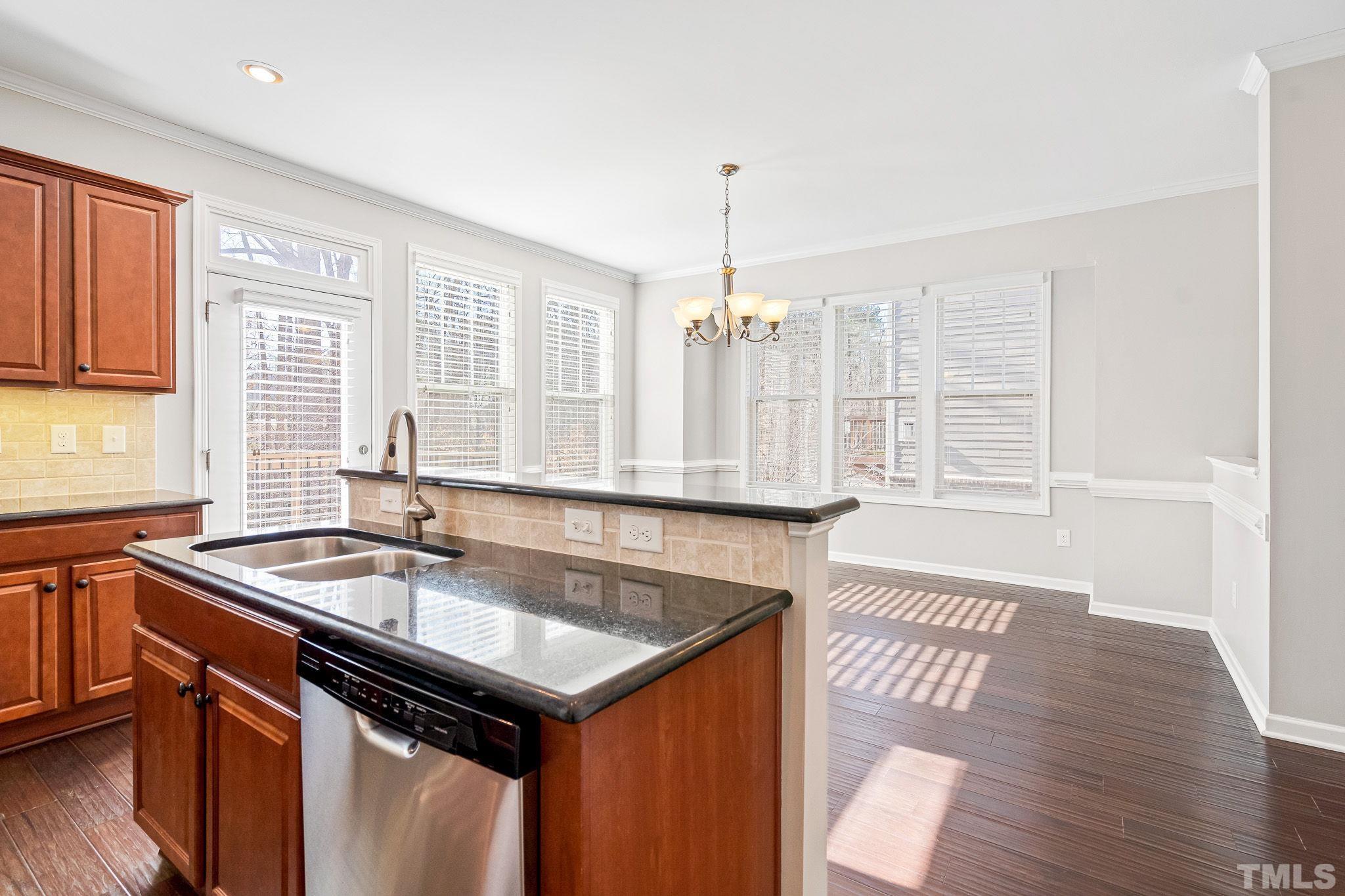 5637 Wade Park Boulevard Raleigh, NC 27607 - Photo 18 of 37 a kitchen with stainless steel appliances granite countertop a sink a oven and wooden floor