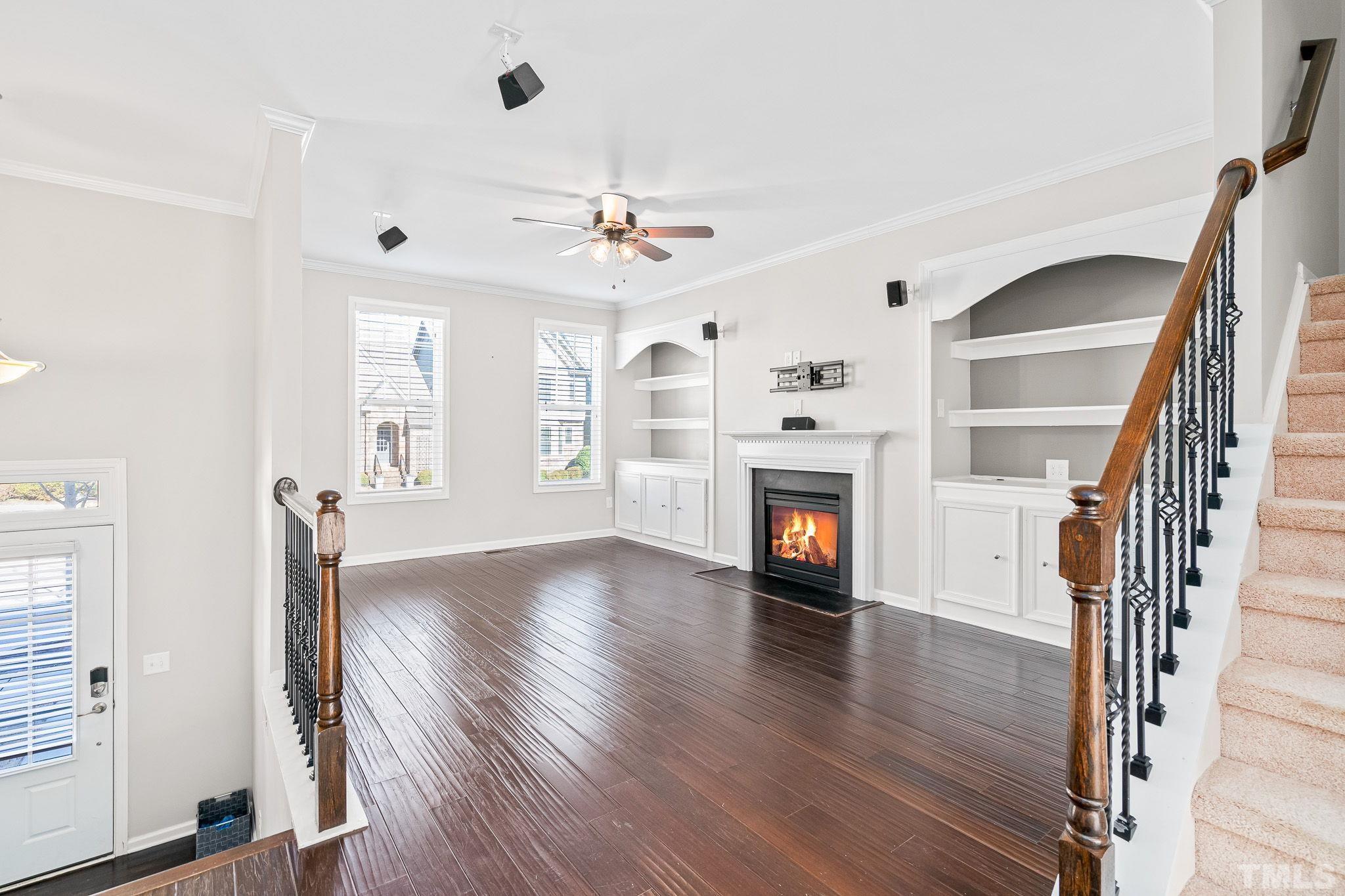 5637 Wade Park Boulevard Raleigh, NC 27607 - Photo 6 of 37 an empty room with wooden floor fireplace and windows