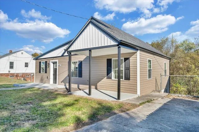a view of a house with backyard and a tree