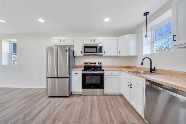 a kitchen with a refrigerator and a stove top oven