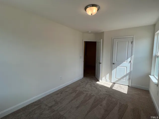an empty room with white walls and sliding door