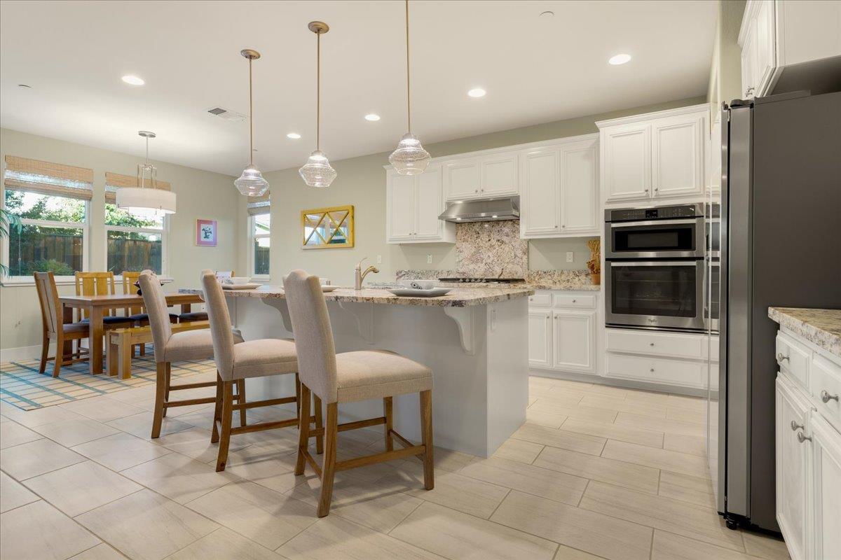 925 Lynx Place Gilroy, CA 95020 - Photo 12 of 49 a kitchen with kitchen island a table and chairs in it