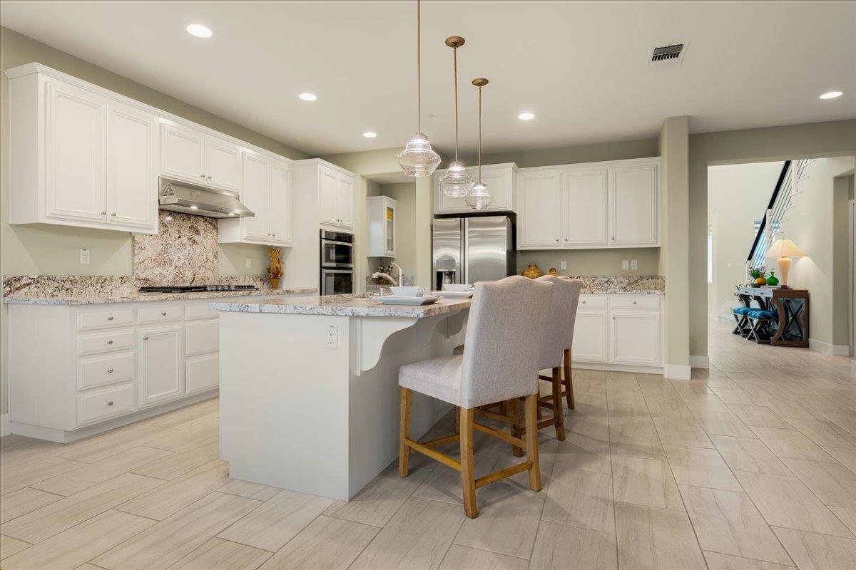 925 Lynx Place Gilroy, CA 95020 - Photo 14 of 49 a kitchen with kitchen island a counter top space appliances and cabinets
