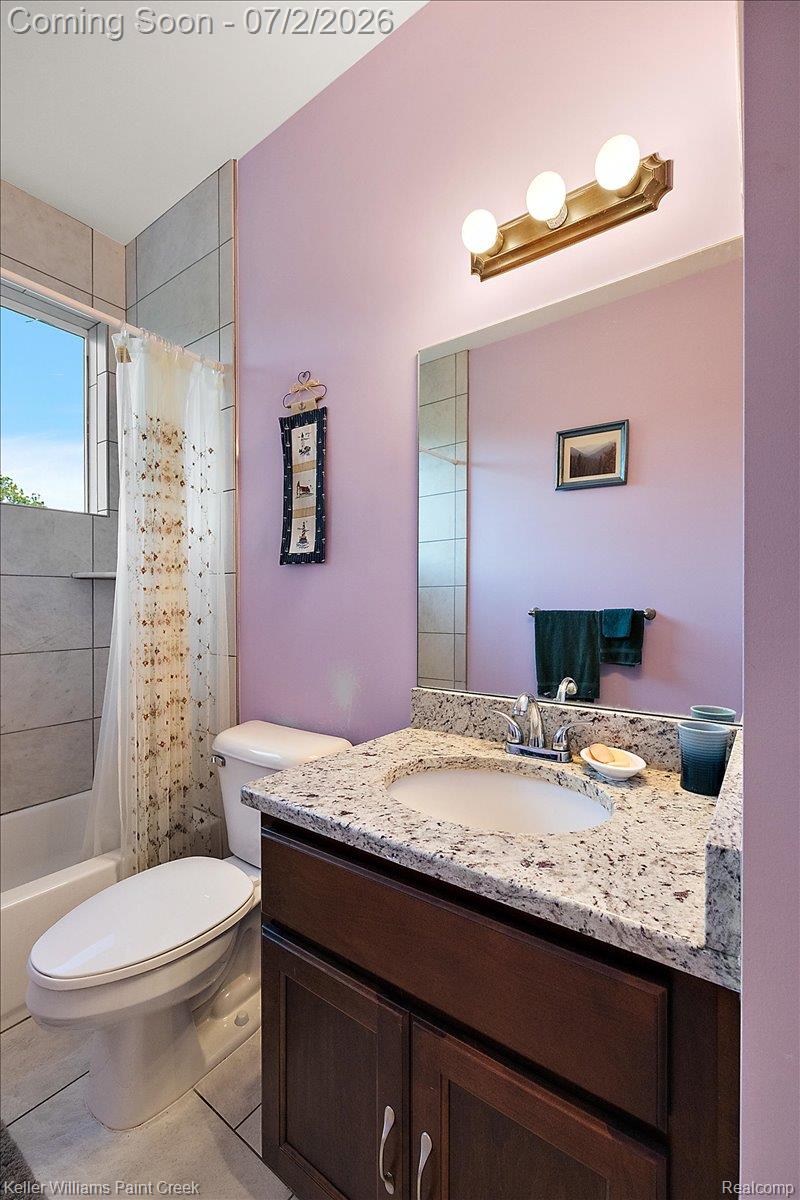 54230 Card Road Macomb, MI 48042 - Photo 62 of 73 Bathroom vanity featuring a light-toned countertop with an integrated sink, dark wood-finish cabinetry, and chrome fixtures