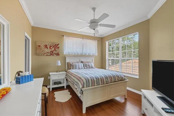 a bedroom with a bed and a flat tv screen on dresser