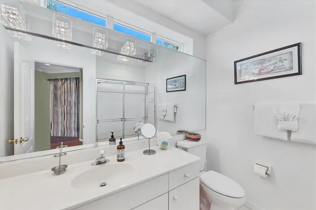 a bathroom with a sink mirror vanity and toilet