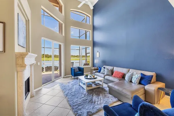 a living room with furniture a flat screen tv and a floor to ceiling window