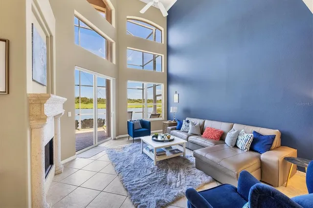 a living room with furniture a flat screen tv and a floor to ceiling window