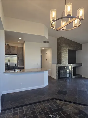 a large kitchen with stainless steel appliances a large counter space a sink and chandelier
