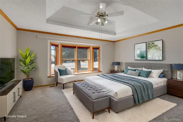 a spacious bedroom with a large bed couch and a potted plant