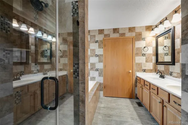 a bathroom with a double vanity sink a mirror and a shower