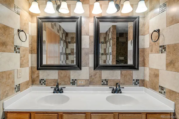 a bathroom with double vanity sinks and a mirror