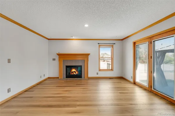 a view of an empty room with a fireplace and a window