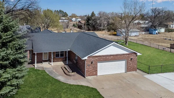 a aerial view of a house with a yard and large tree