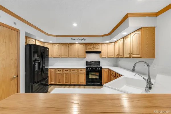 a kitchen with stainless steel appliances granite countertop a refrigerator a sink a stove and island