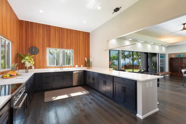 a large kitchen with a large window and wooden floor