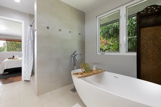 a bathroom with a tub a sink and a shower