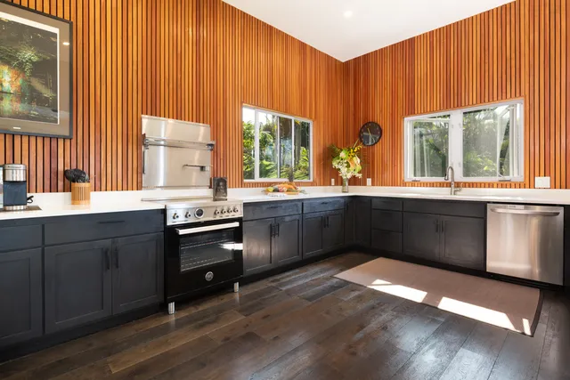 a kitchen with stainless steel appliances wooden cabinets a sink and a large window