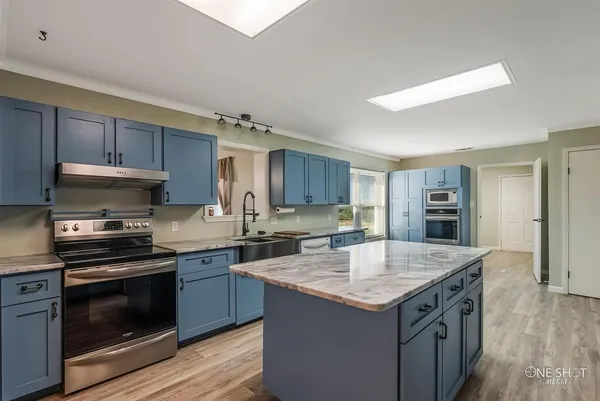 a kitchen with a stove sink and cabinets