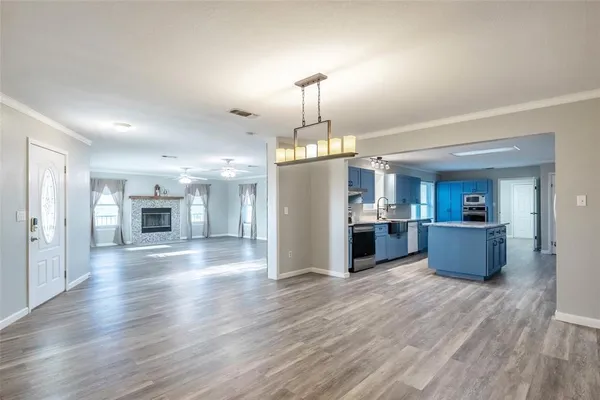 a kitchen with a refrigerator and a wooden floor