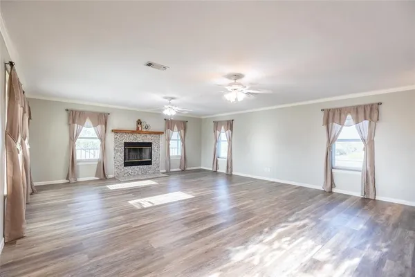 a view of empty room with wooden floor and fireplace