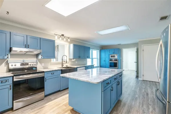 a kitchen with granite countertop a sink stove and refrigerator