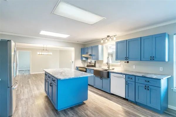 a kitchen with granite countertop kitchen island wooden floors and wooden cabinets