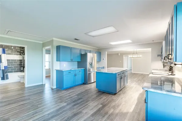 a large kitchen with stainless steel appliances granite countertop a lot of counter space and wooden floor