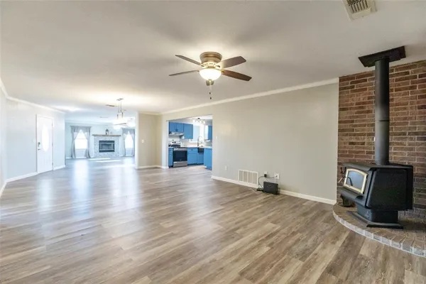 a view of empty room with wooden floor and a ceiling fan