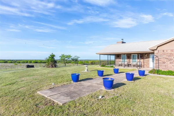 a view of an outdoor space with dining table and chairs