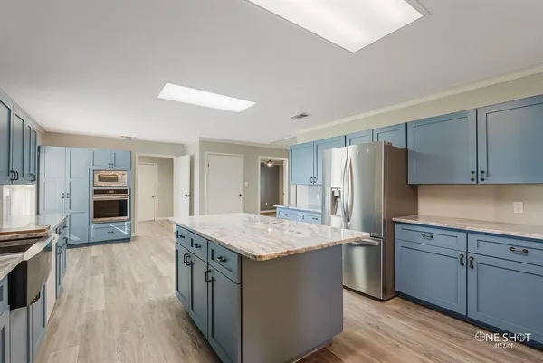 a kitchen with a stove a sink a refrigerator and cabinets