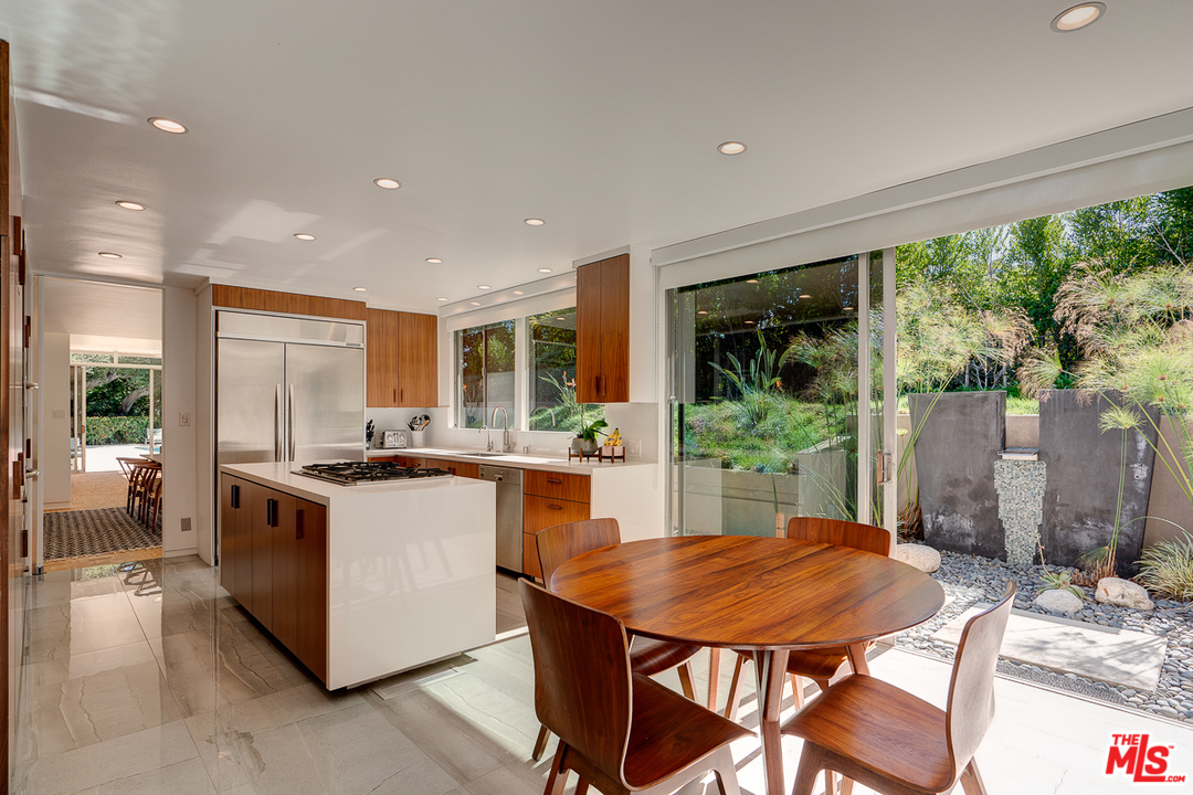 1490 El Mirador Drive Pasadena, CA 91103 - Photo 15 of 52 a kitchen with a stove a refrigerator a sink dining table and chairs
