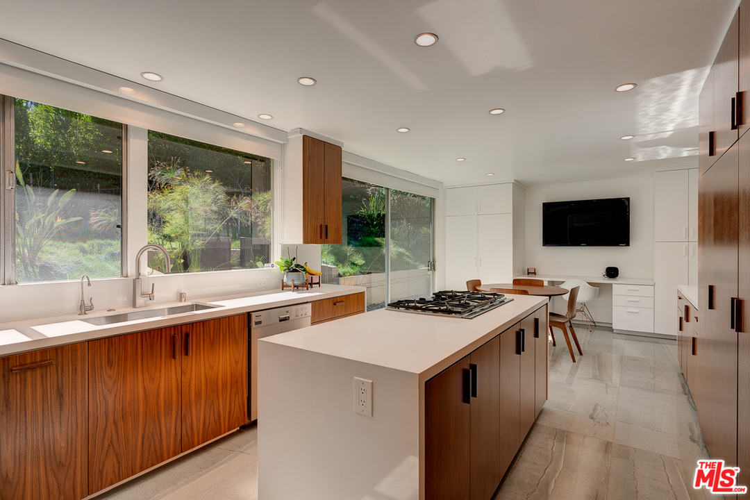 1490 El Mirador Drive Pasadena, CA 91103 - Photo 16 of 52 a kitchen with a stove a sink a microwave and a dining table