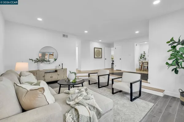 a living room with lots of furniture and kitchen view