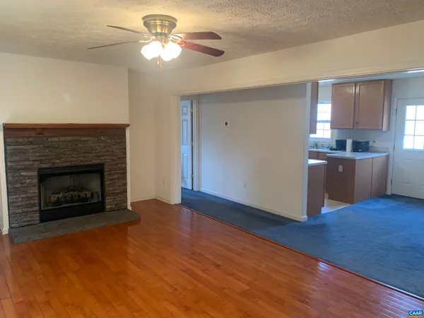a living room with stainless steel appliances granite countertop furniture and a fireplace