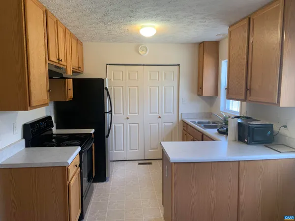 a kitchen with stainless steel appliances a stove refrigerator sink and cabinets
