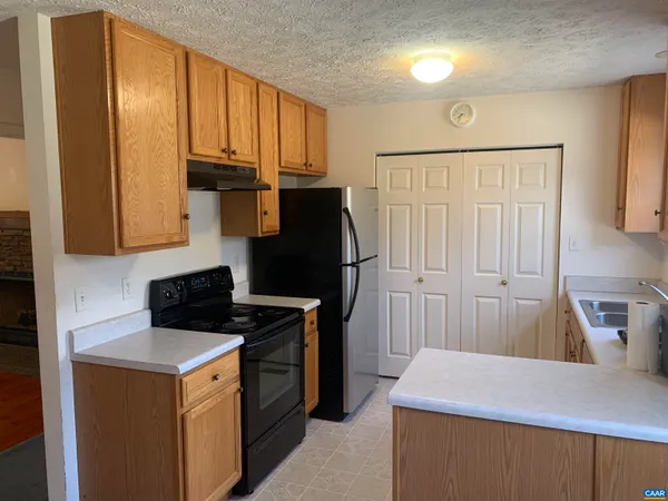a kitchen with a stove a refrigerator and cabinets