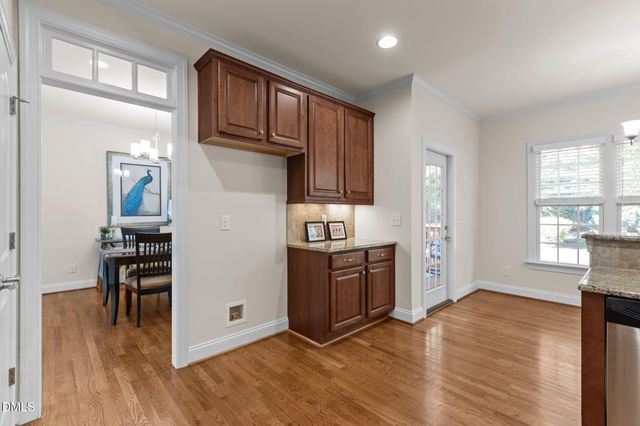 a kitchen with stainless steel appliances granite countertop a refrigerator microwave and wooden floor